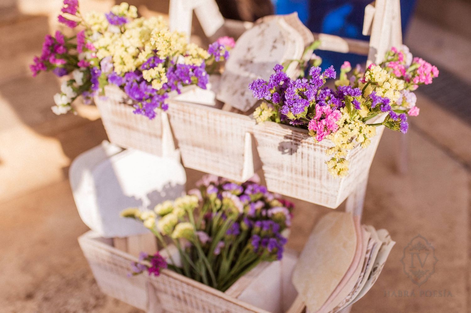 Decoración floral de boda con cajas de madera y flores moradas y amarillas