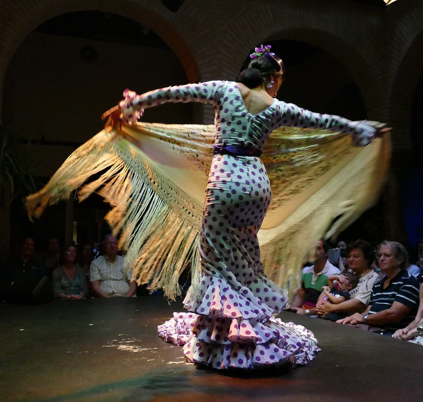 Bailaora de flamenco con mantón y vestido de lunares